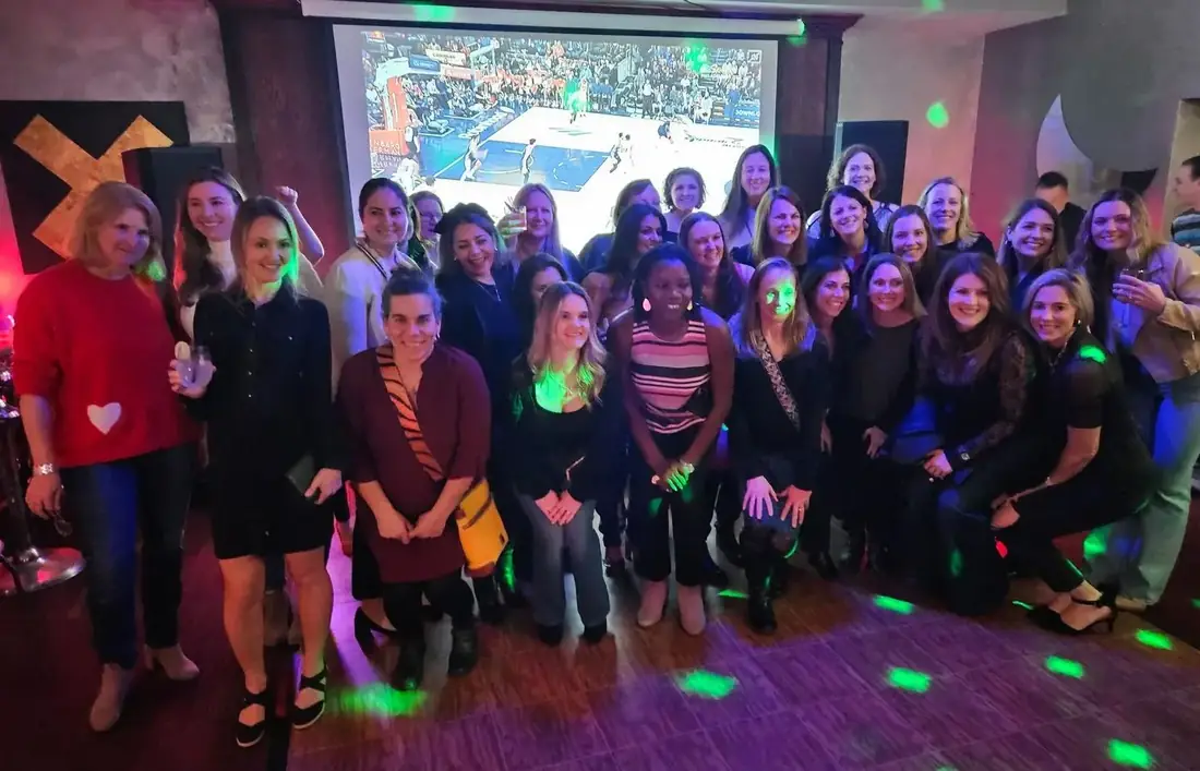 A large group of guests gathered together on the dance floor at Midtown Social for a community event.