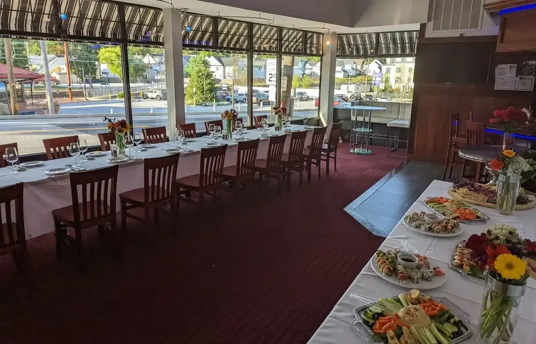 A daytime event on the first floor at Midtown Social with a long set table by the windows and a buffet of sushi and charcuterie.