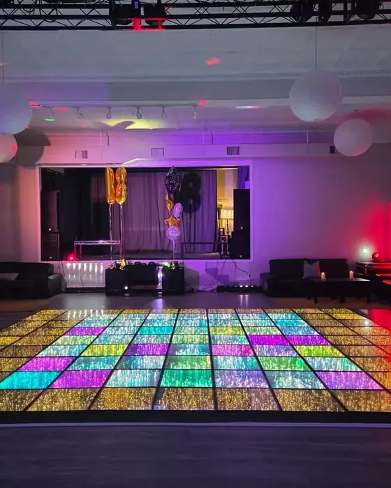 Midtown Hall with the LED dance floor lit in rainbow colors, lounge seating and the stage beyond.